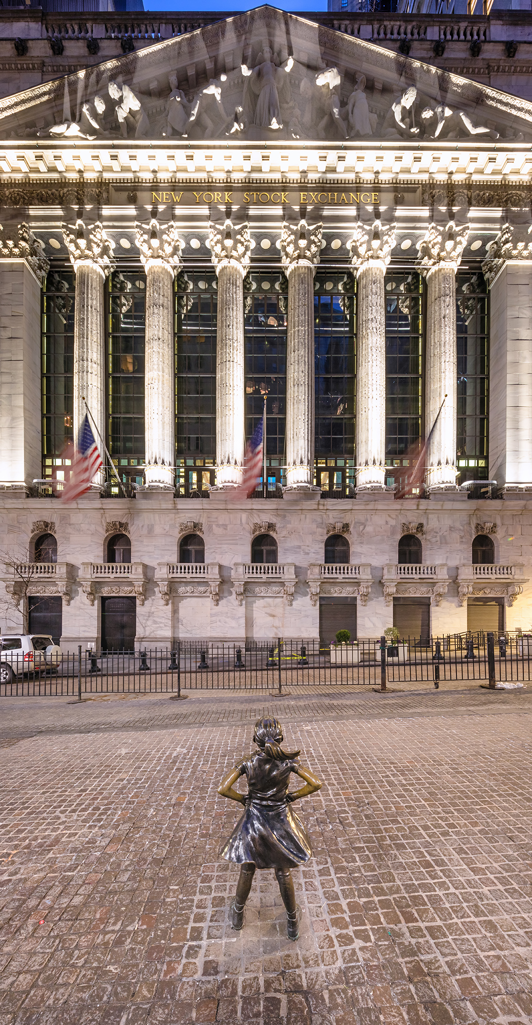 The New York Stock Exchange with Fearless Girl standing in front, in Manhattan's Financial District